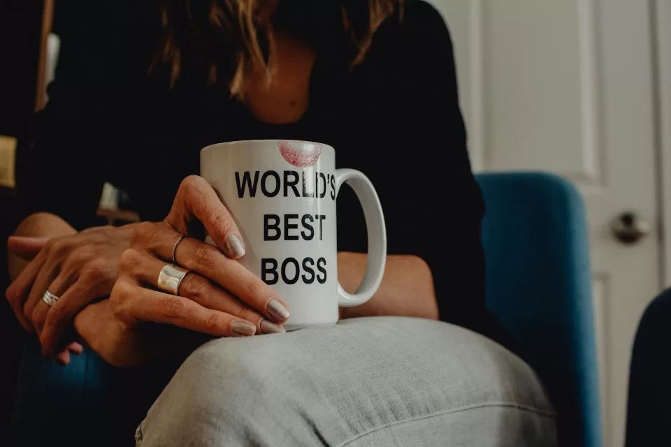 Woman's hand holding "World's Best Boss" mug